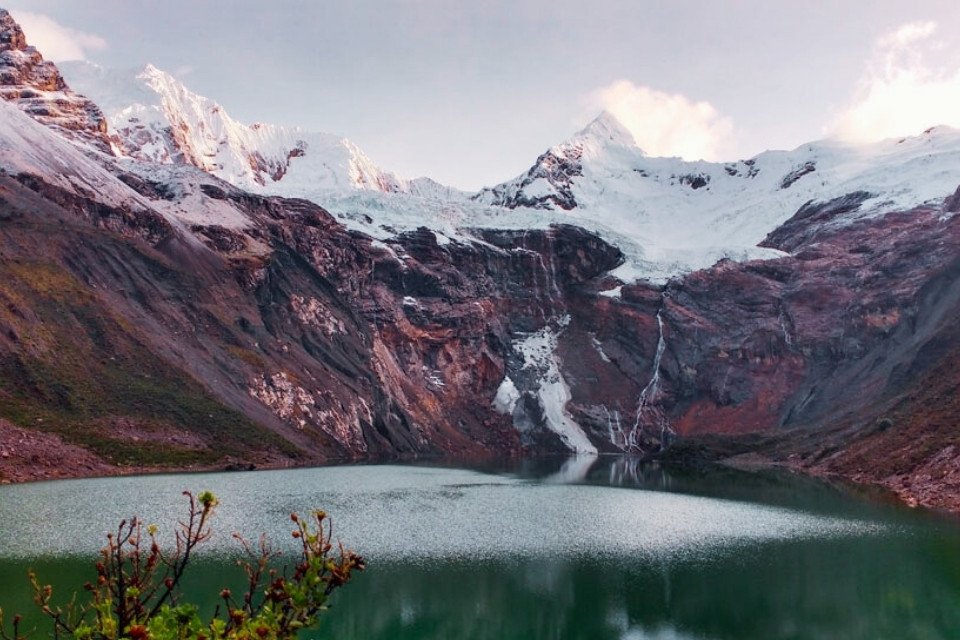 Stunning turquoise glacial lagoon and snow-capped peaks of the Huantsán massif in the Cordillera Blanca, Peru – a high-altitude expedition by Andeando Peru.